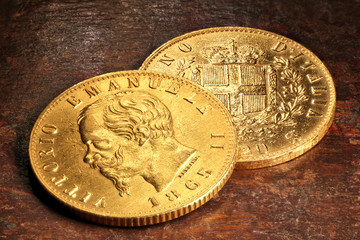 Italienische 20 Lire Goldmünzen auf rustikalem Holztisch