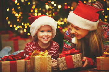 Fototapeta na wymiar Happy family mother and child girl with Christmas present