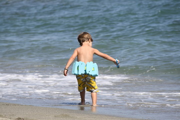 Corsica, Caucasian boy playing in waves at beach
