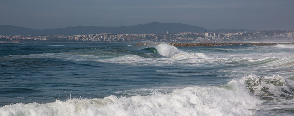 Ocean waves in Costa da Caparica. Autumn day in Almada, Portugal.
