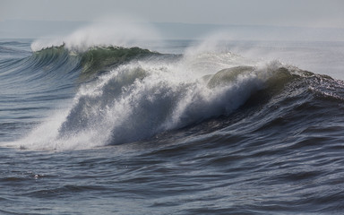 Ocean waves in Costa da Caparica. Autumn day in Almada, Portugal.

