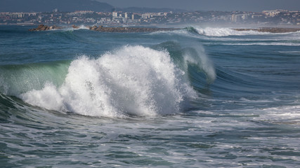 Ocean waves in Costa da Caparica. Autumn day in Almada, Portugal.
