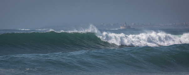 Ocean waves in Costa da Caparica. Autumn day in Almada, Portugal.
