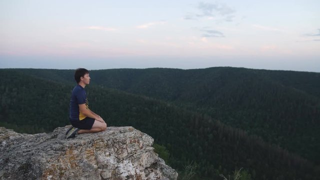 Man sitting on the top of the mountain in meditation session