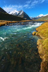 landscape of mountain peaks and swift rivers in the fall.