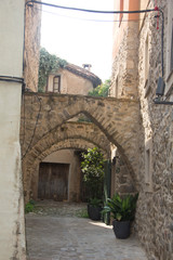 Fototapeta na wymiar Narrow street in the medieval town with stone houses.
