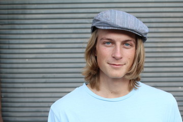 Streetkid. Young man with long hair wearing classic old school hat 