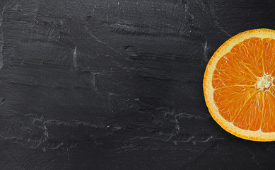 orange fresh cut on black stone. focus on orange fresh cut. with copy space for your text