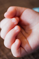 Close up detail of caucasian older baby or younger toddler's fingers and hand