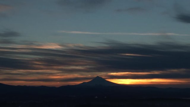 Night to day time lapse from the Portland Oregon skyline with sun rising behind snowy Mt Hood on beautiful morning.