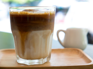Iced coffee in wooden plate on table