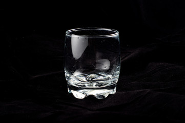 Empty glass on black velvet