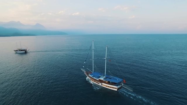 Aerial View of Swimming Ship in a Bay with Depp Blue Water. Sunset on Sea, Shot in 4K UHD
