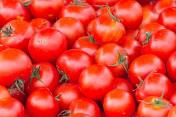 Group of tomatoes in market place. Red round ripe background. Ketchup production