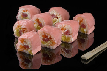 Pink beaters and wooden sticks for sushi on black acryle