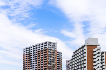Real estate image, tower apartment building against blue sky