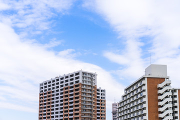 Fototapeta premium Real estate image, tower apartment building against blue sky