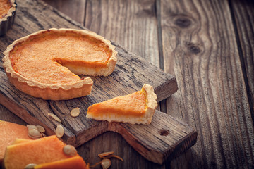 Thanksgiving pumpkin pie on wooden background with copy space