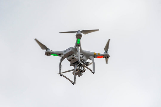 A drone with a camera flying high above a residential area
