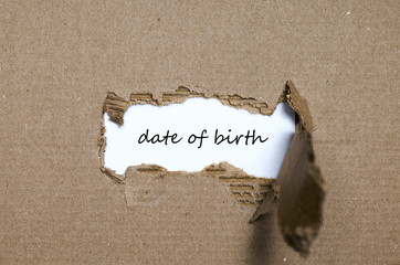 The word date of birth appearing behind torn paper