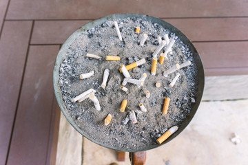 Cigarette in outdoors ashtray with sand closeup  process with vi
