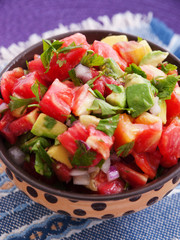 Tomatoes and avocado salad with red onion. Vertical shot