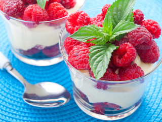 Cream desserts with raspberries and mint in a glass. Horizontal