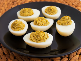Stuffed eggs with mustard and yolk in a plate. Horizontal shot