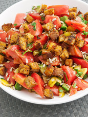 Salad from tomatoes, green peppers, sunflower seeds and croutons