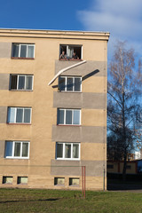 Seniors throwing rolled carpet out of a window of a building