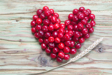 red cherry heart on wood table