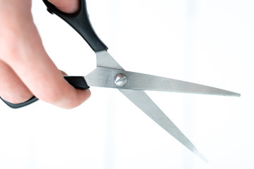 the hand holds the scissors for thinning out on an isolated white background
