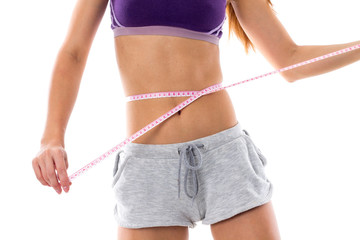 Sportive woman measuring her waist