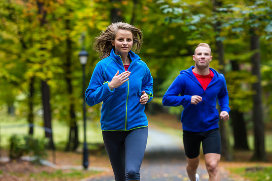 Woman and man running in park