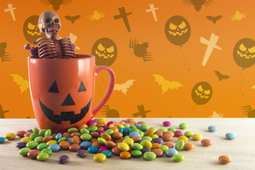 skeleton in cup with candy halloween party wallpaper