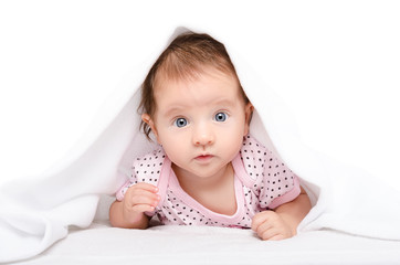 Portrait of a cute baby lying under towel