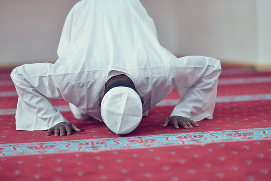 African Muslim Man Making Traditional Prayer To God While Wearing A Traditional Cap Dishdash