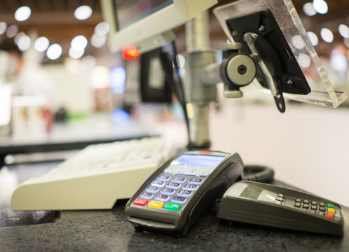 Hand Swiping Credit Card on POS terminal in Store