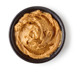 Peanut butter in round dish isolated on white background