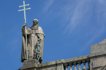 Naklejka premium Steinerne Statue eines christlichen Heiligen mit Doppelkreuz oder Spanischem Kreuz und Kette. 