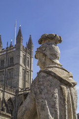 Back of statue of Ceasar at the Roman baths with view on the cathedral of Bath in Somerset