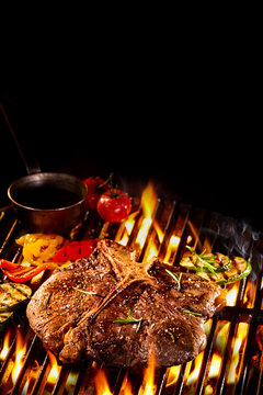 T bone steak on flaming grill with copy space