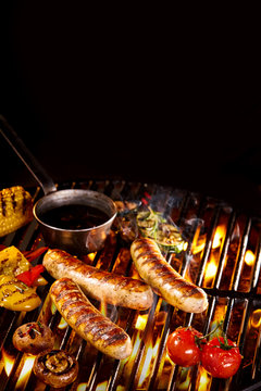 Grilled sausages besides peppers and tomatoes