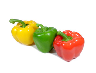 Close-up of three ripe bell peppers, yellow and green and red, with stem isolated on white background 