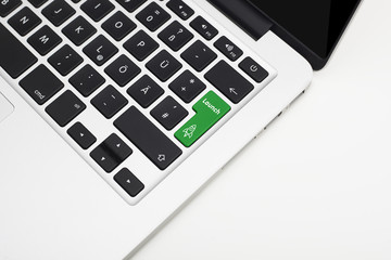 Laptop's keyboard with green Launch key and copyspace 