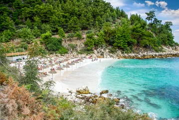 Foto op Canvas Marble beach (Saliara beach), Thassos Islands, Greece. The most beautiful white beach in Greece. Tourists enjoying a nice day at the beach. Straw umbrellas (straw parasol) and sunbeds on the beach. © Lucian Bolca
