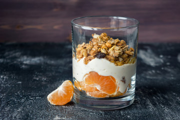 Natural yogurt with muesli, slices of mandarin fruit and honey. Sweet parfait. 
