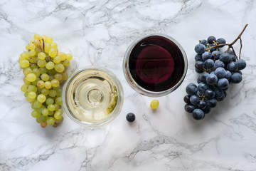 Wine in a wineglass on marble table with fresh fruit. Red and white wine. Top view