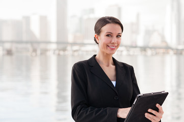 Businesswoman with digital tablet and miami skyline in backgroun