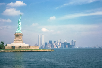 Statue of Liberty and Twin Towers, destroyed in September 11, 2001, of World Trade Center. New York City skyline view from the ferry boat. Symbols NYC, United States. - obrazy, fototapety, plakaty